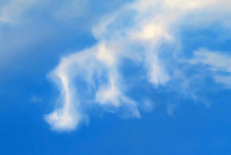 Drei Wolken am blauen Himmel sehen aus wie Noten.